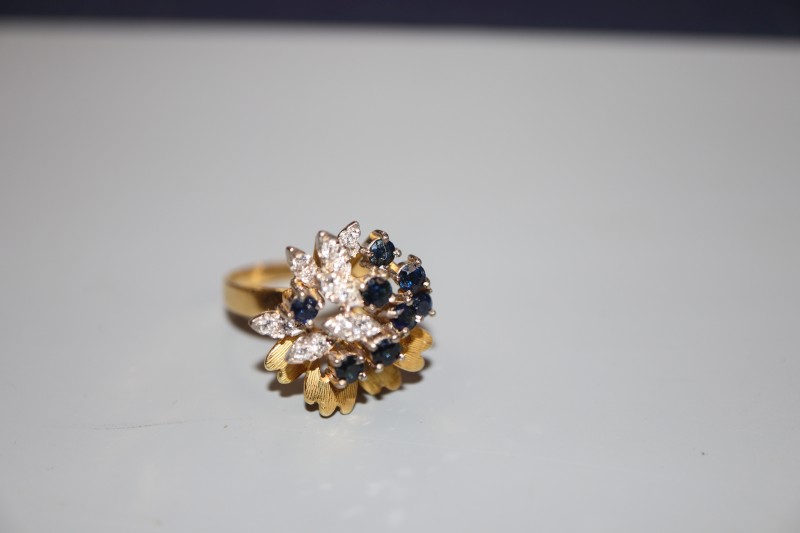A modern 18ct gold, sapphire and diamond raised cluster dress ring, size N, gross 7.4 grams.